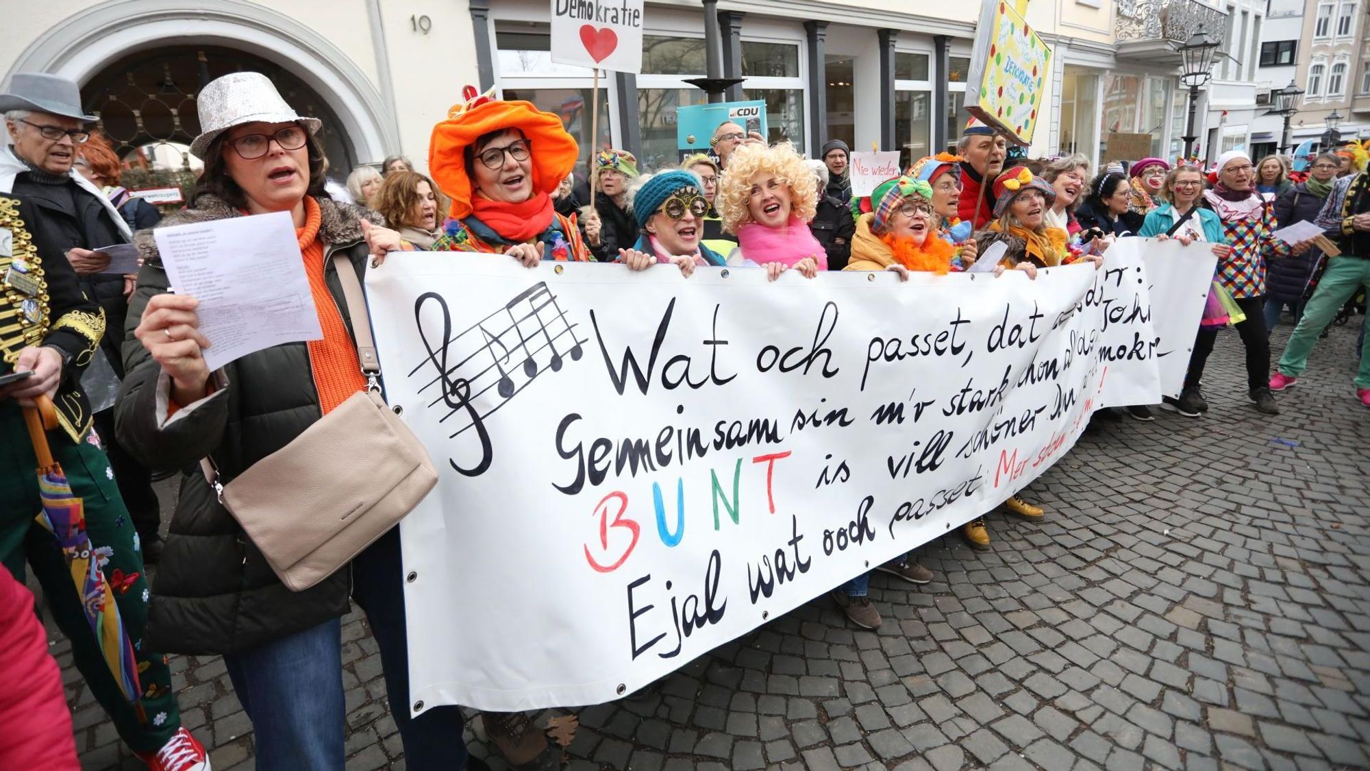 Karnevalisten halten auf der Demonstration unter dem Motto „Karnevalisten gegen Faschisten“ ein Plakat hoch.