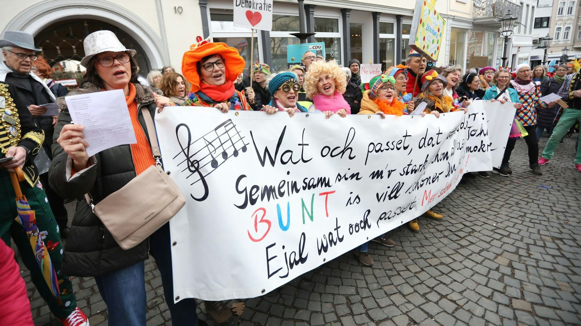 Karnevalisten halten auf der Demonstration unter dem Motto „Karnevalisten gegen Faschisten“ ein Plakat hoch.