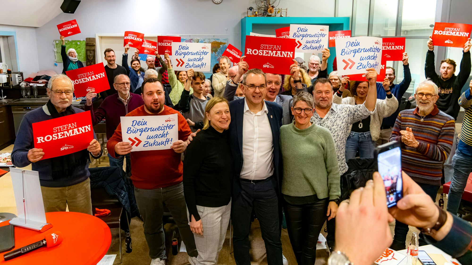 Mitglieder eines Parteivereins halten Wahlplakate in die Höhe.