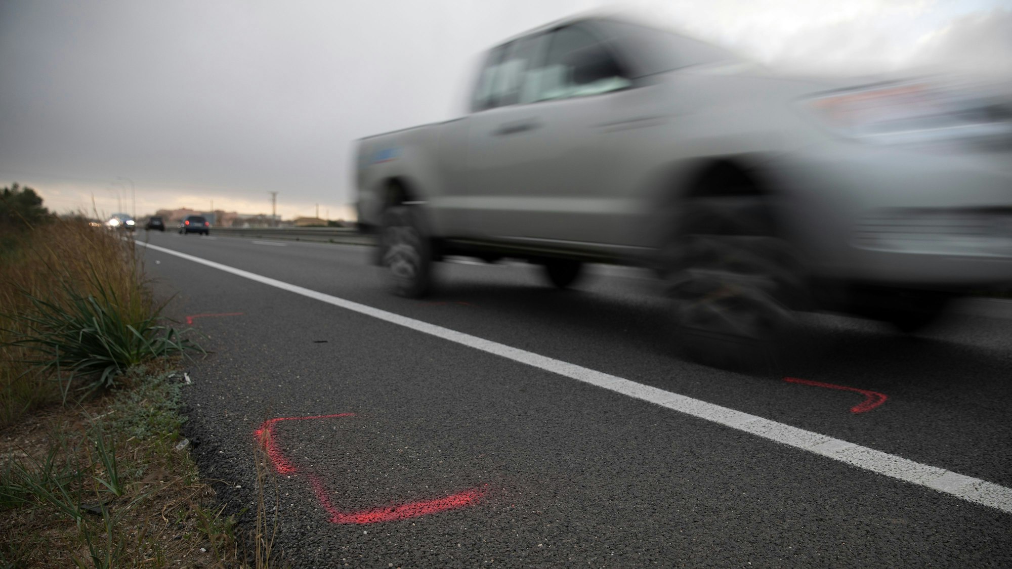 Markierungen sind auf der Straße auf Mallorca zu sehen, nachdem sich hier am Vormittag der schwere Unfall ereignet hatte.