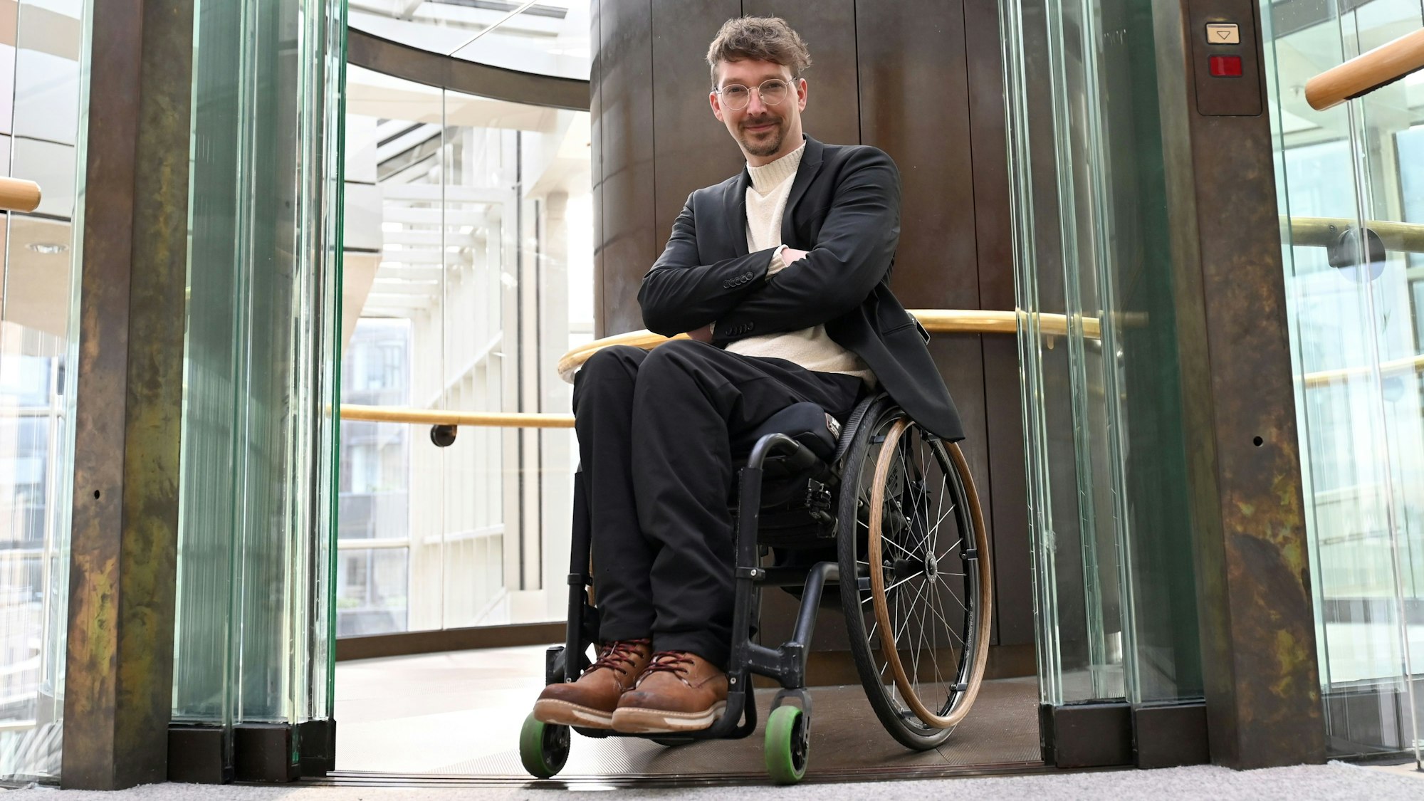 Dennis Sonne (Bündnis 90/Die Grünen), Mitglied des Landtages von Nordrhein-Westfalen, sitzt im Rollstuhl und ist im Landtag zu sehen.