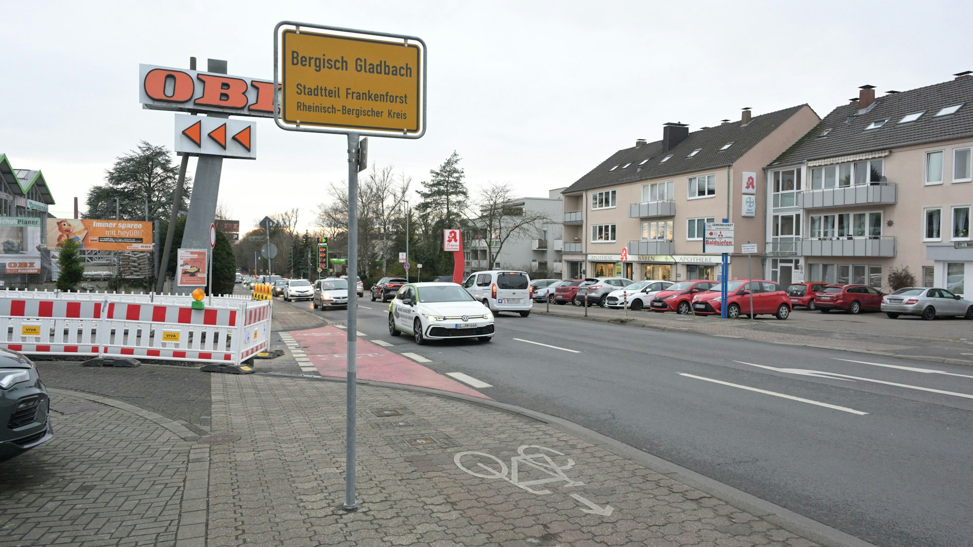 Ein gelbes Ortsschild mit dem Schriftzug„ Bergisch Gladbach“ steht neben einem Fahrradweg.