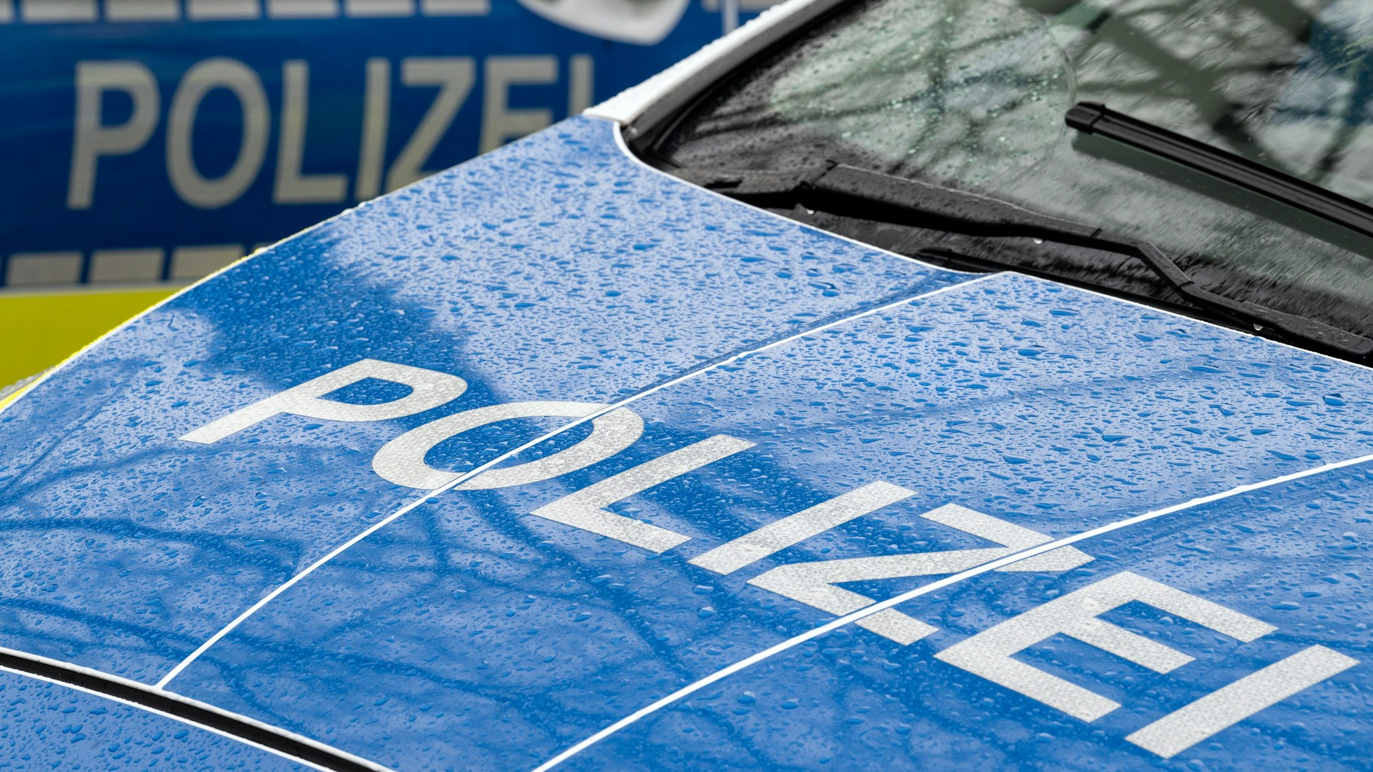 Der Schriftzug „Polizei“ steht auf der Kühlerhaube eines Autos.