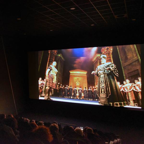 Ein Kinosaal, auf der Leinwand eine Szene aus der Oper „Aida“.