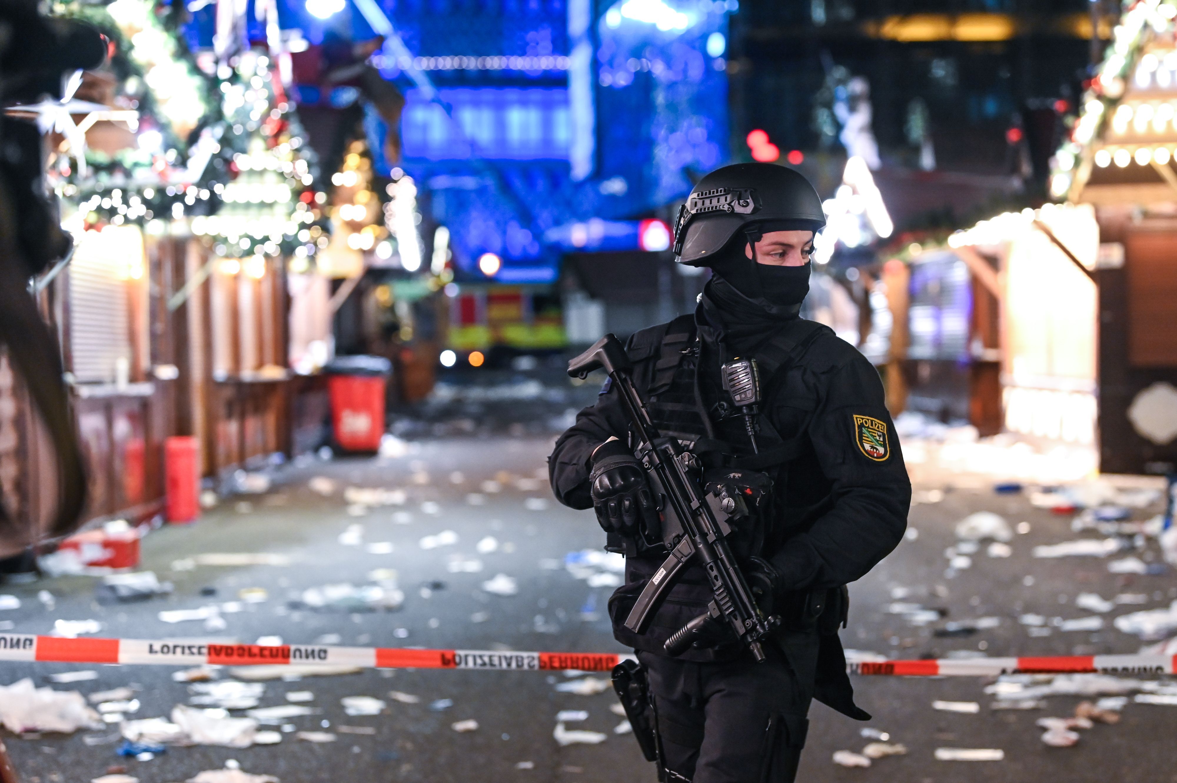Ein schwer bewaffneter Polizist auf dem verwüsteten Weihnachtsmarkt in Magdeburg