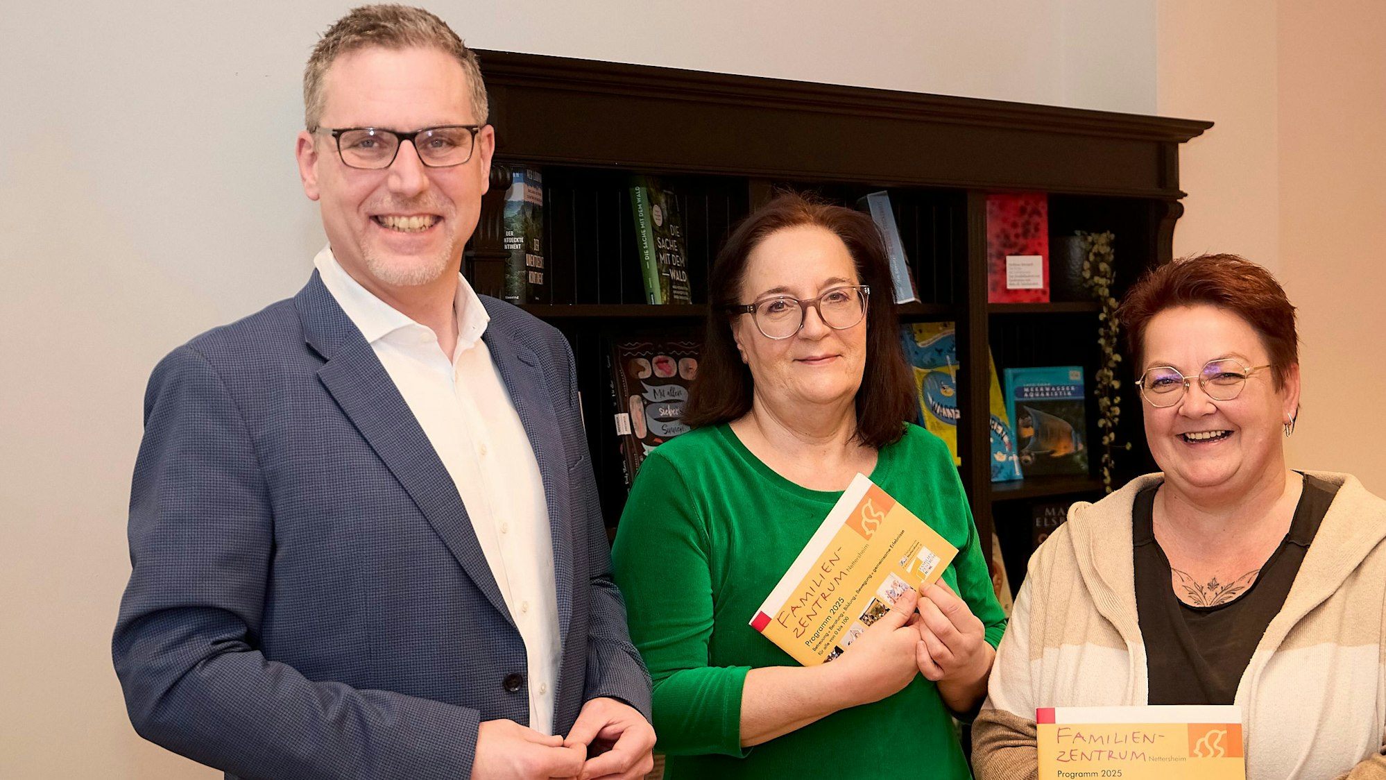 Iris Beging und Brigitte Wies halten das Programmheft in der Hand, Norbert Crump steht links daneben.