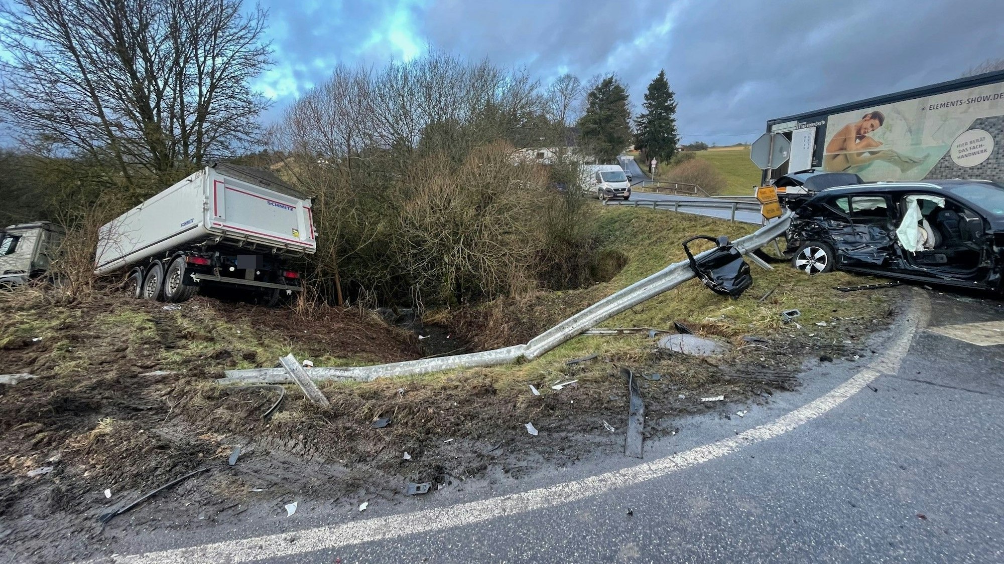 Der Sattelschlepper steckt tief im Graben. Ein zweiter Lkw steht auf der Fahrbahn.