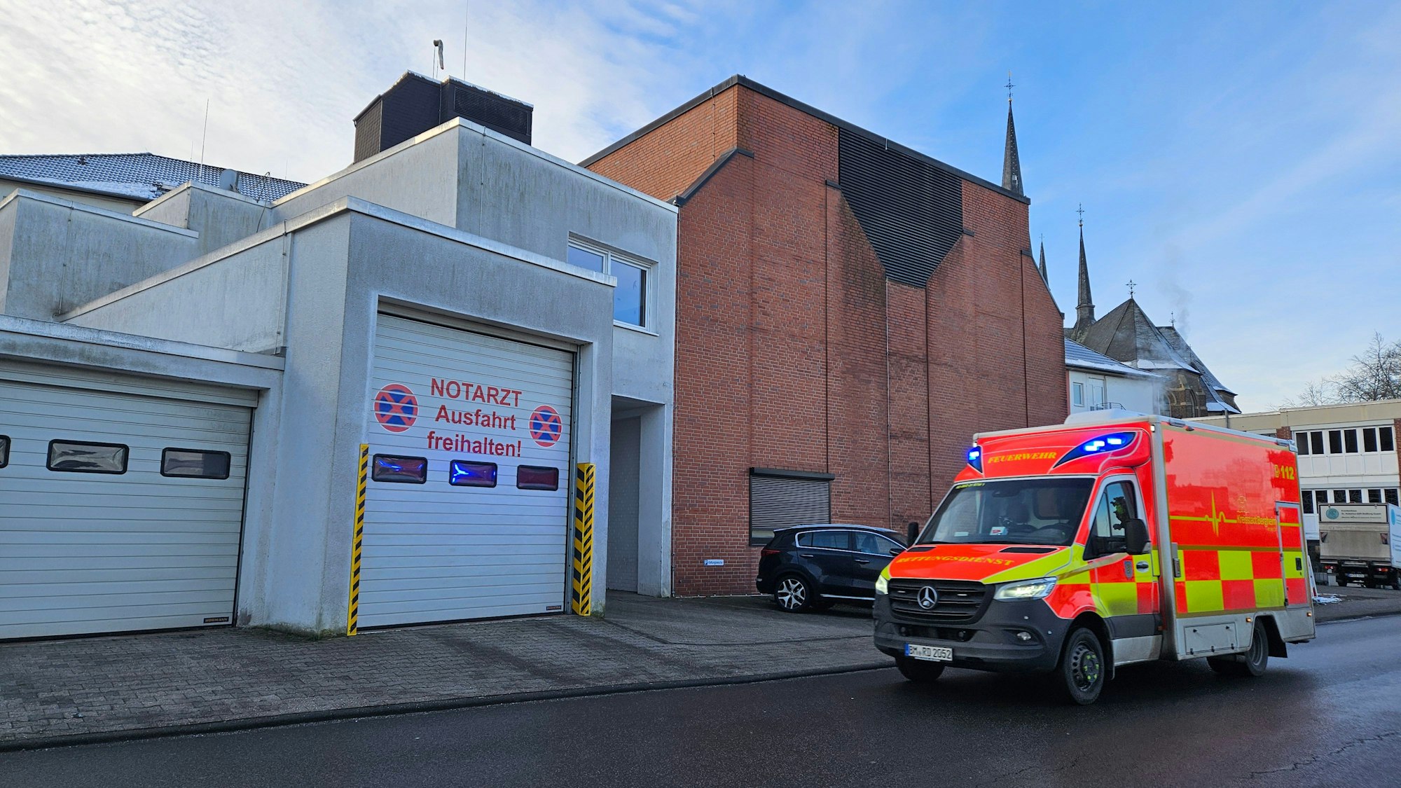 Zu sehen ist ein Rettungswagen, der am Krankenhaus Bedburg vorbeifährt.