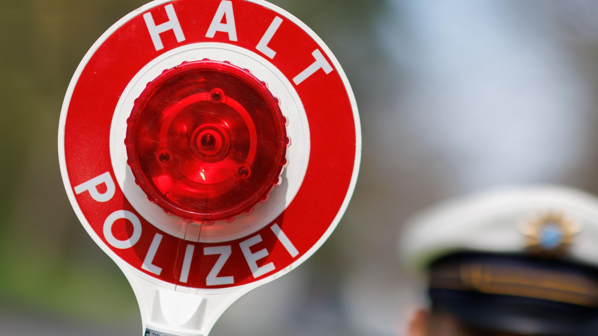 Das Bild zeigt eine Polizeikelle mit der Aufschrift "Halt Polizei".