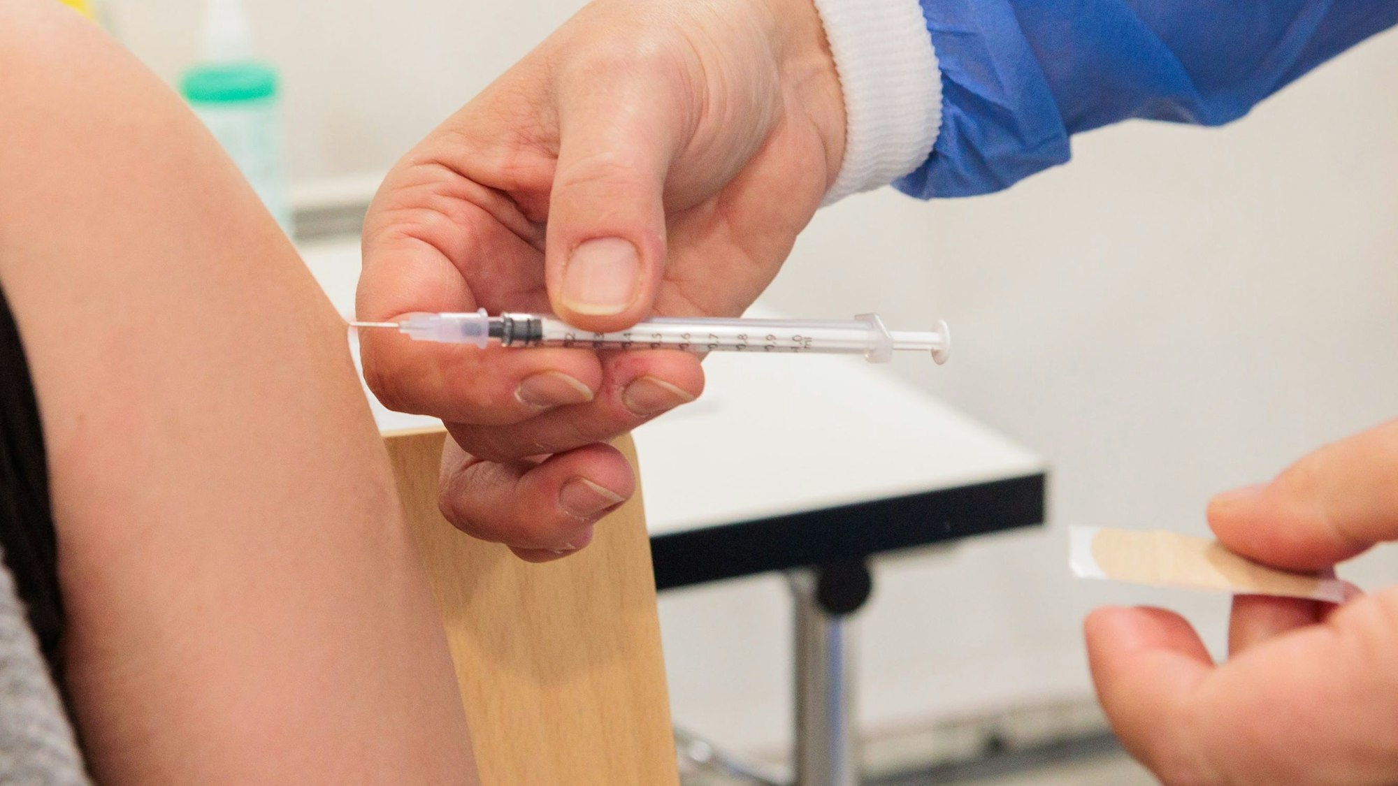 Zu sehen ist der Oberarm eines Menschen, in dem eine Spritze steckt.