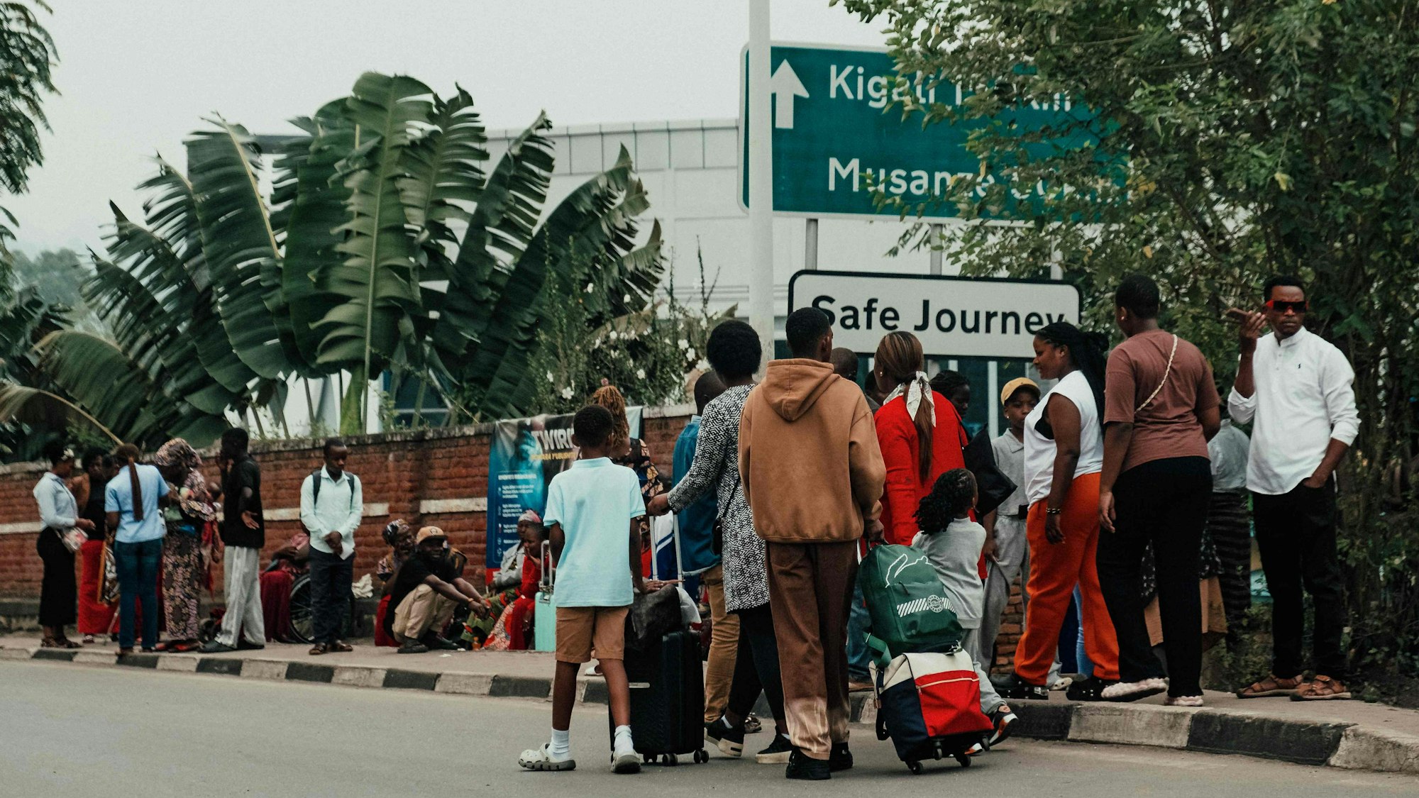 Menschen mit kleinem Reisegepäck an einem Grenzübergang.