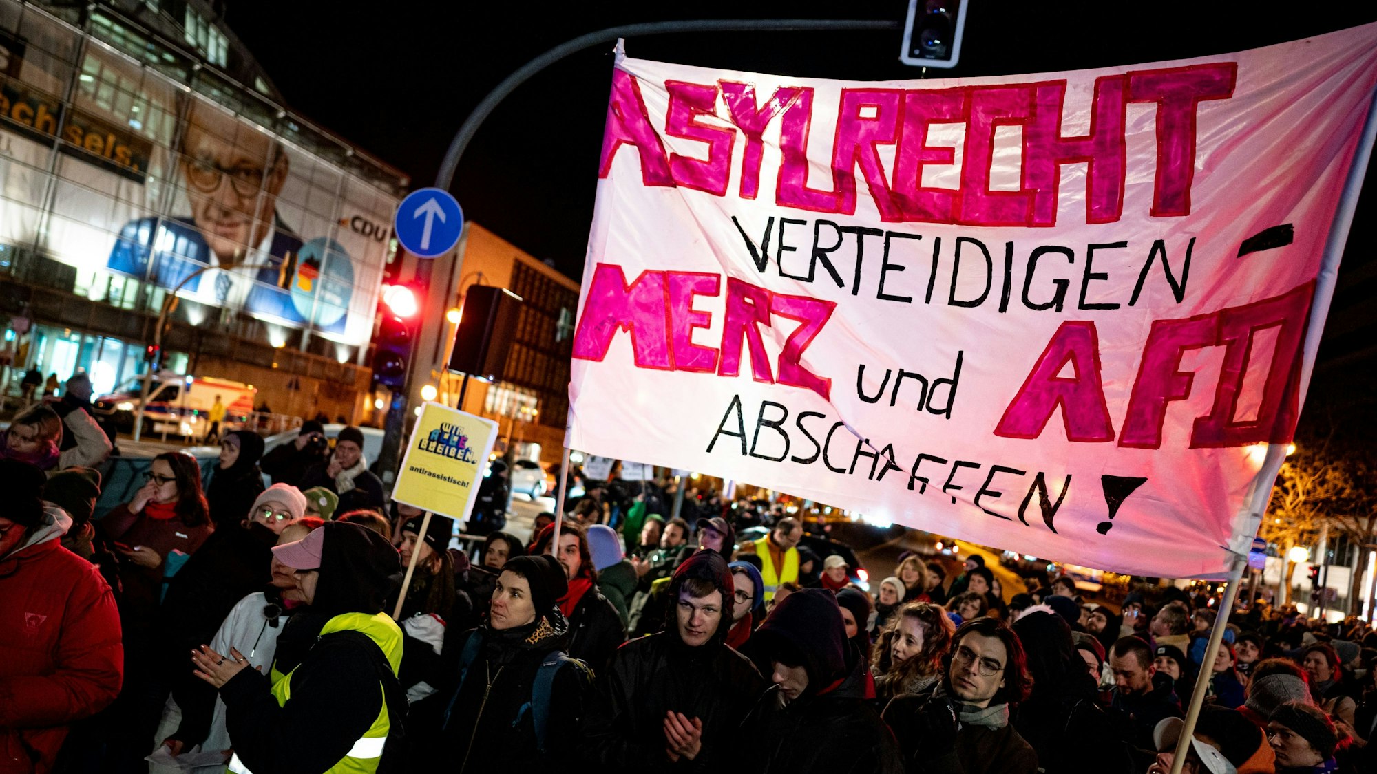 29.01.2025, Berlin: Menschen nehmen an der Kundgebung «Brandmauer statt Brandstiftung» von Amnesty International, Seebrücke und anderen Organisationen mit einem Banner mit der Aufschrift «Asylrecht verteidigen Merz und AfD abschaffen» vor der CDU Zentrale teil. Foto: Fabian Sommer/dpa +++ dpa-Bildfunk +++
