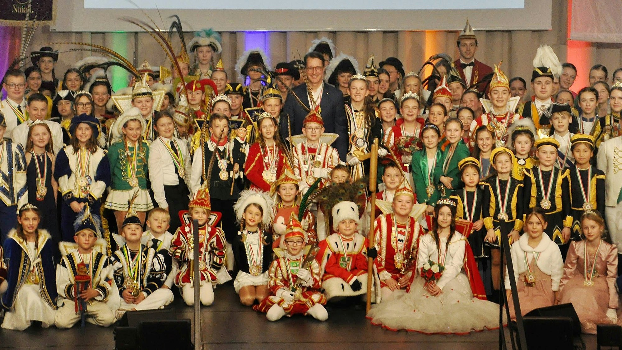 Zahlreiche Kindertollitäten aus ganz NRW stehen auf einem Foto, in der Mitte ist Ministerpräsident Hendrik Wüst zu sehen.