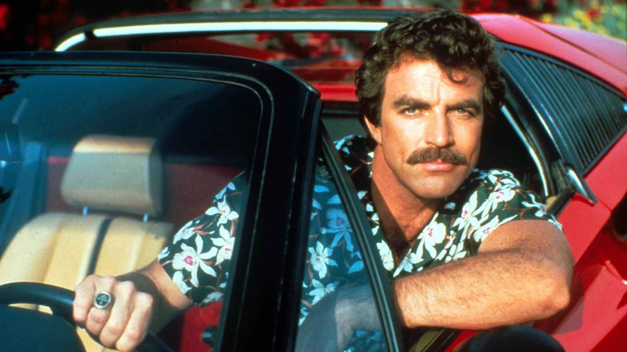 Tom Selleck sitzt in seiner Rolle als Thomas Magnum im Auto.