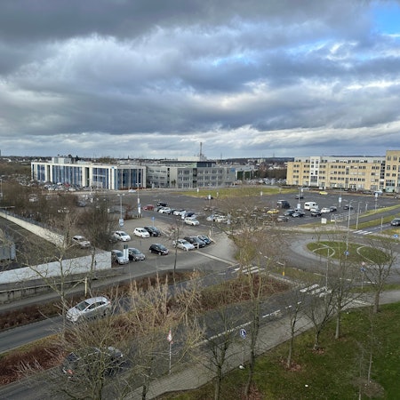 Links das Technische Rathaus der Stadt, in der Bildmitte die freie Fläche mit Parkplatz, die nun erst einmal nicht bebaut wird.