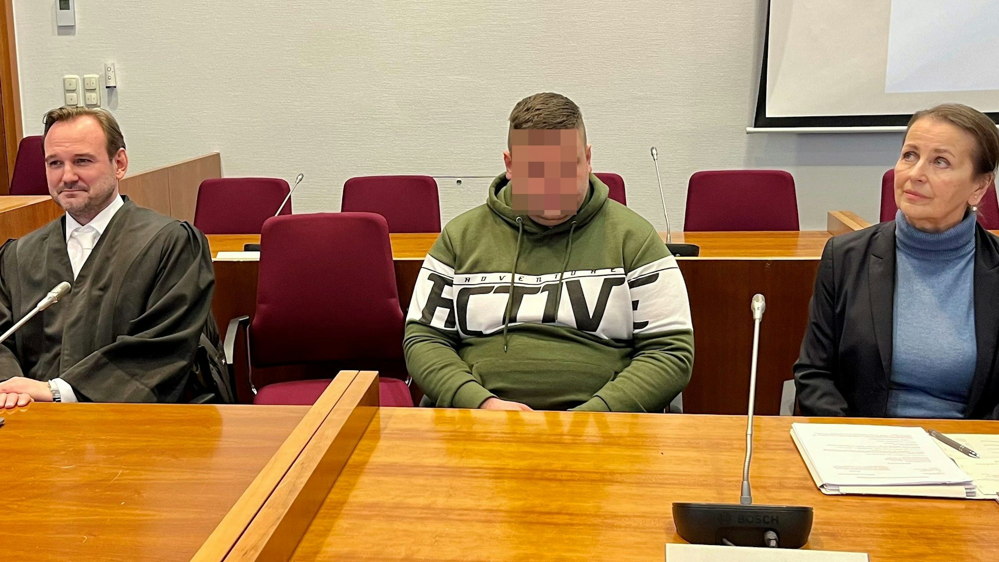 Im Bonner Landgericht sitzt der mutmaßliche Täter, der im August 2024 in Hennef eine 81-Jahre alte Frau beraubt und vergewaltigt haben soll, zwischen seinen Verteidigern auf der Anklagebank.