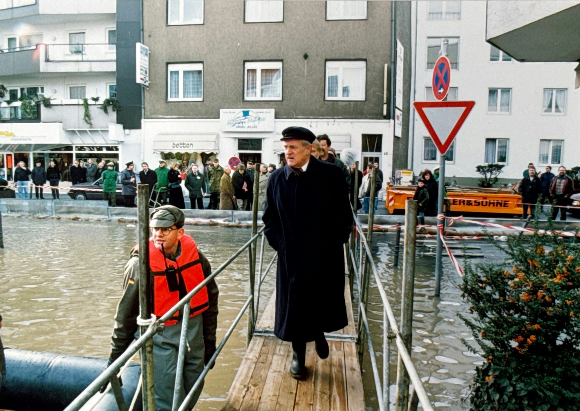 30.01.1995, Köln: Hochwasser. Ministerpräsident Johannes Rau geht über einen mobilen Steg an der Rodenkirchener Hauptstraße (im Hintergrund Hausnummer 62) während daneben ein Soldat der Bundeswehr mit einer Rettungsweste im Wasser steht.  Foto: Walter Schiestel