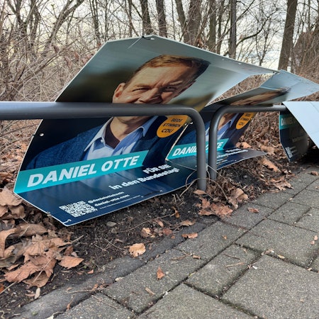 Beschädigte Wahlplakate des CDU-Kandiaten liegen an der Neuenhöfer Allee im Ortsteil Sülz am Straßenrand.