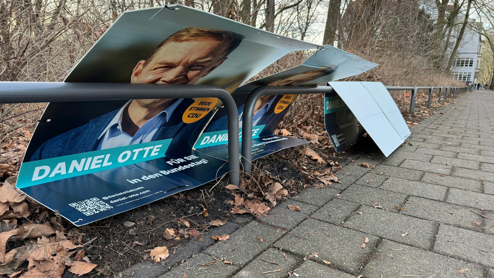 Beschädigte Wahlplakate des CDU-Kandiaten liegen an der Neuenhöfer Allee im Ortsteil Sülz am Straßenrand.