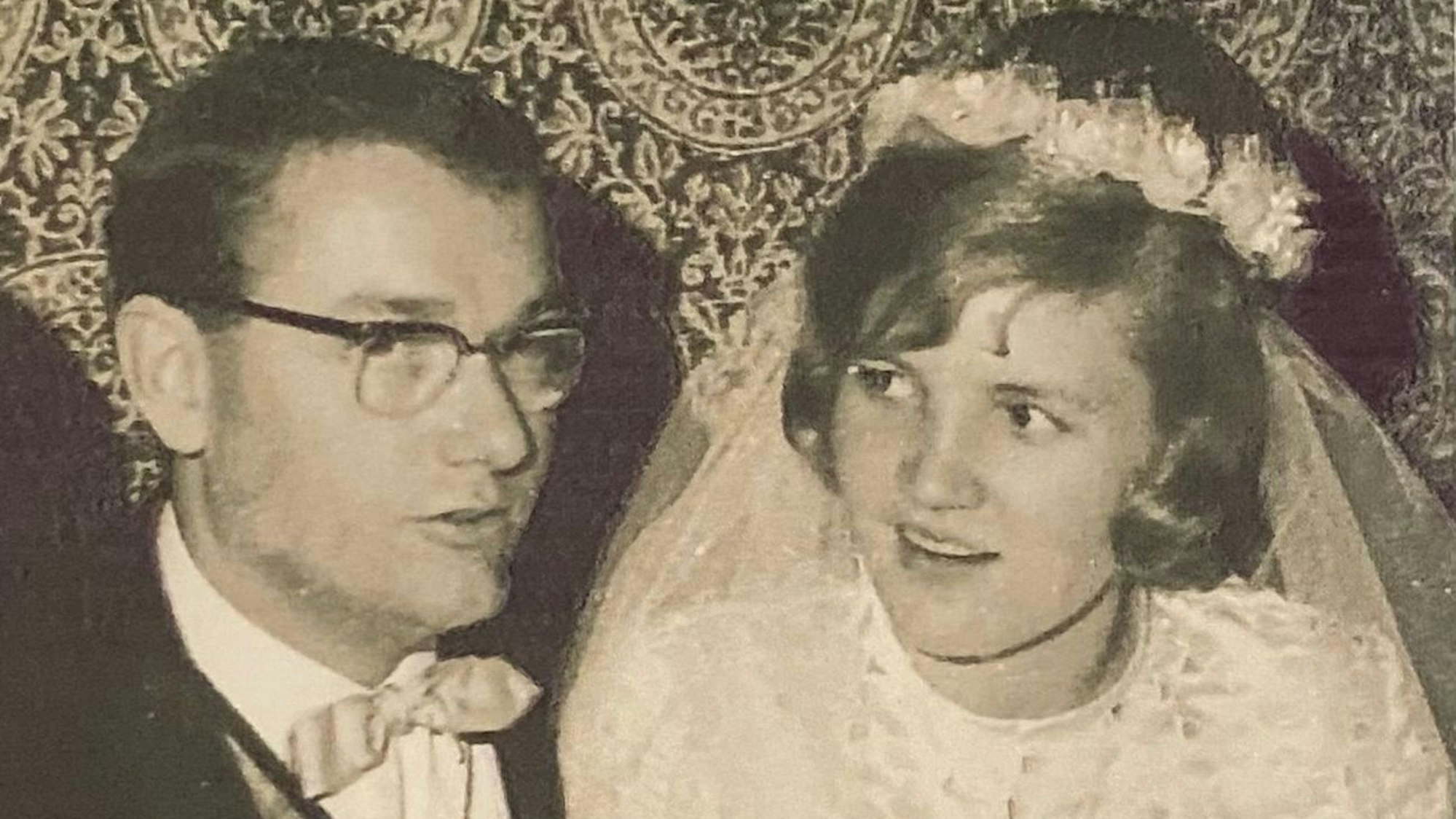 Zu sehen ist ein Brautpaar bei der Hochzeit in schwarz-weiß.