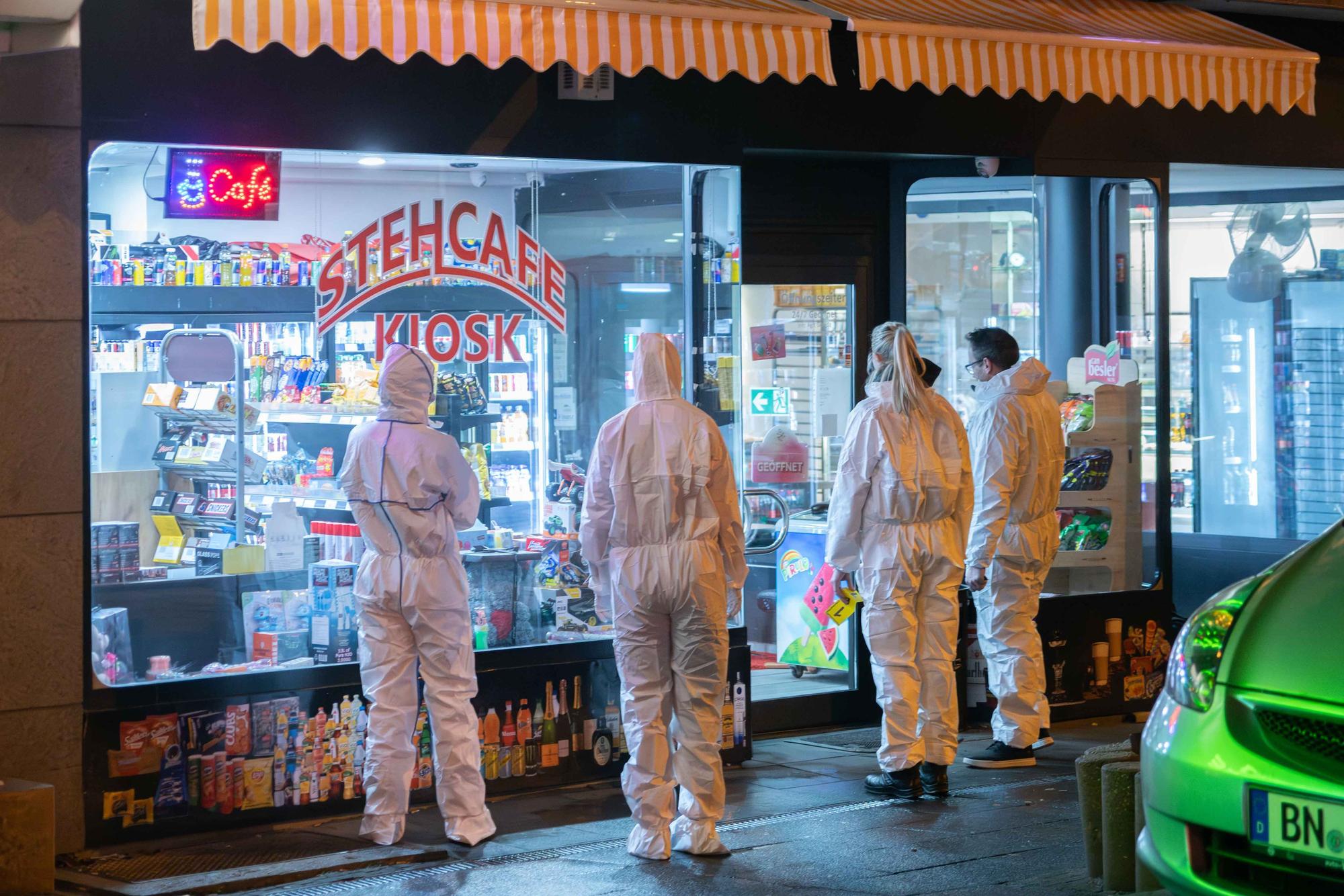Ermittler der Kölner Polizei stehen vor dem Kiosk, in dem auf den Betreiber geschossen wurde.