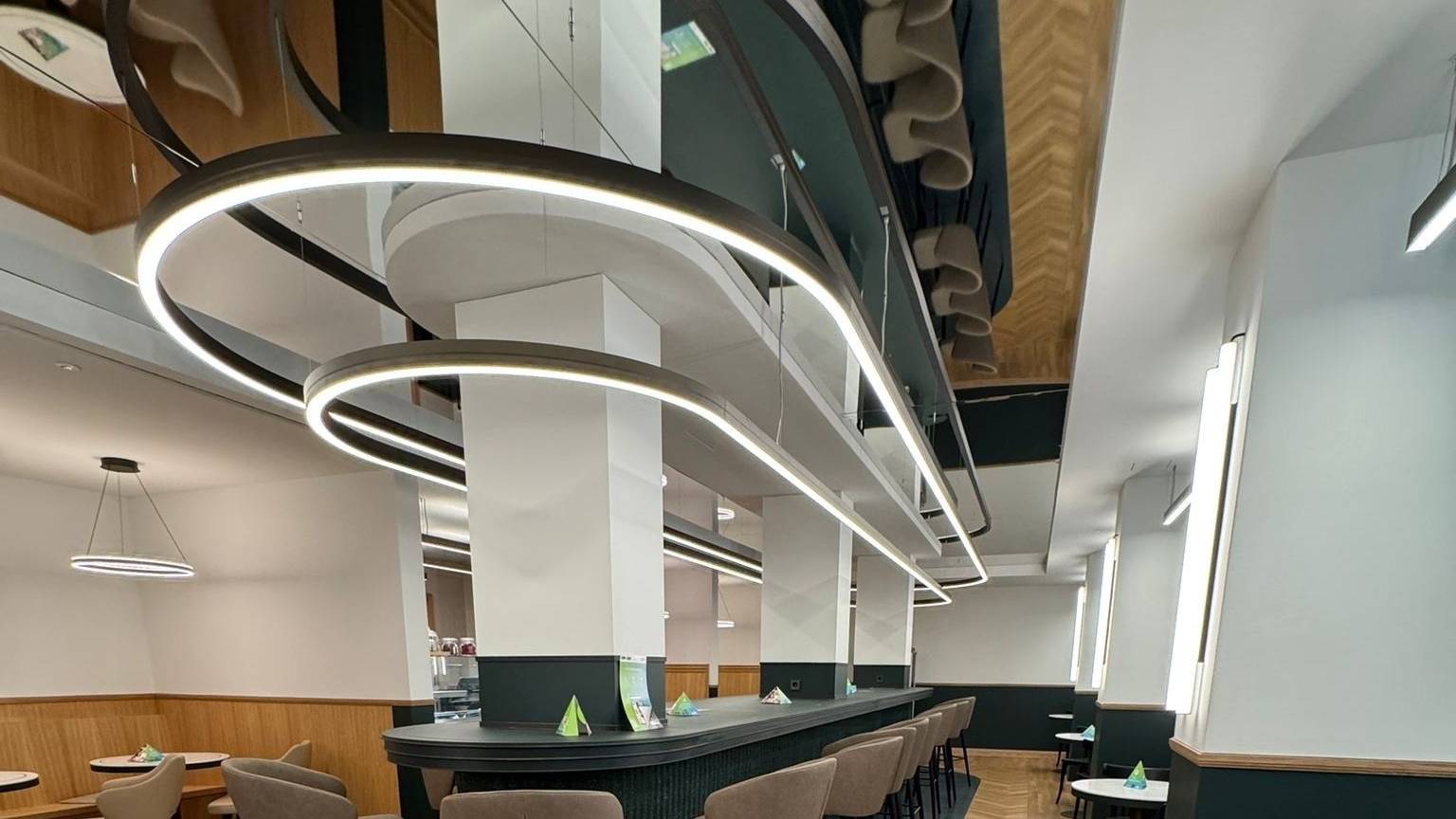 Das Bistro ist zu sehen ohne Gäste: ein schicker Thekenbereich mit gepolsterten Hochstühlen.