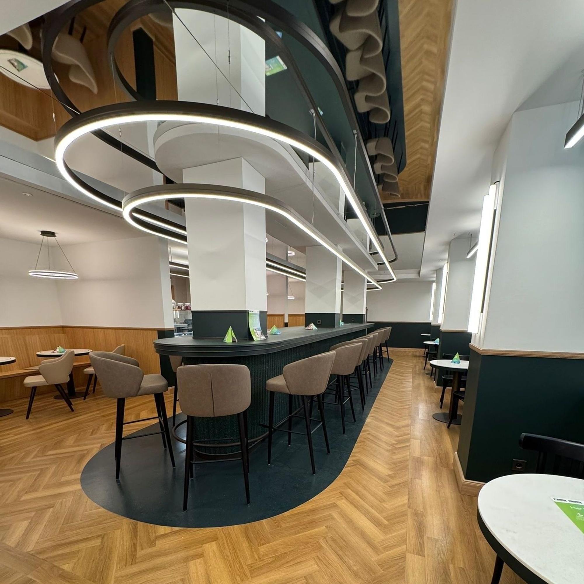 Das Bistro ist zu sehen ohne Gäste: ein schicker Thekenbereich mit gepolsterten Hochstühlen.