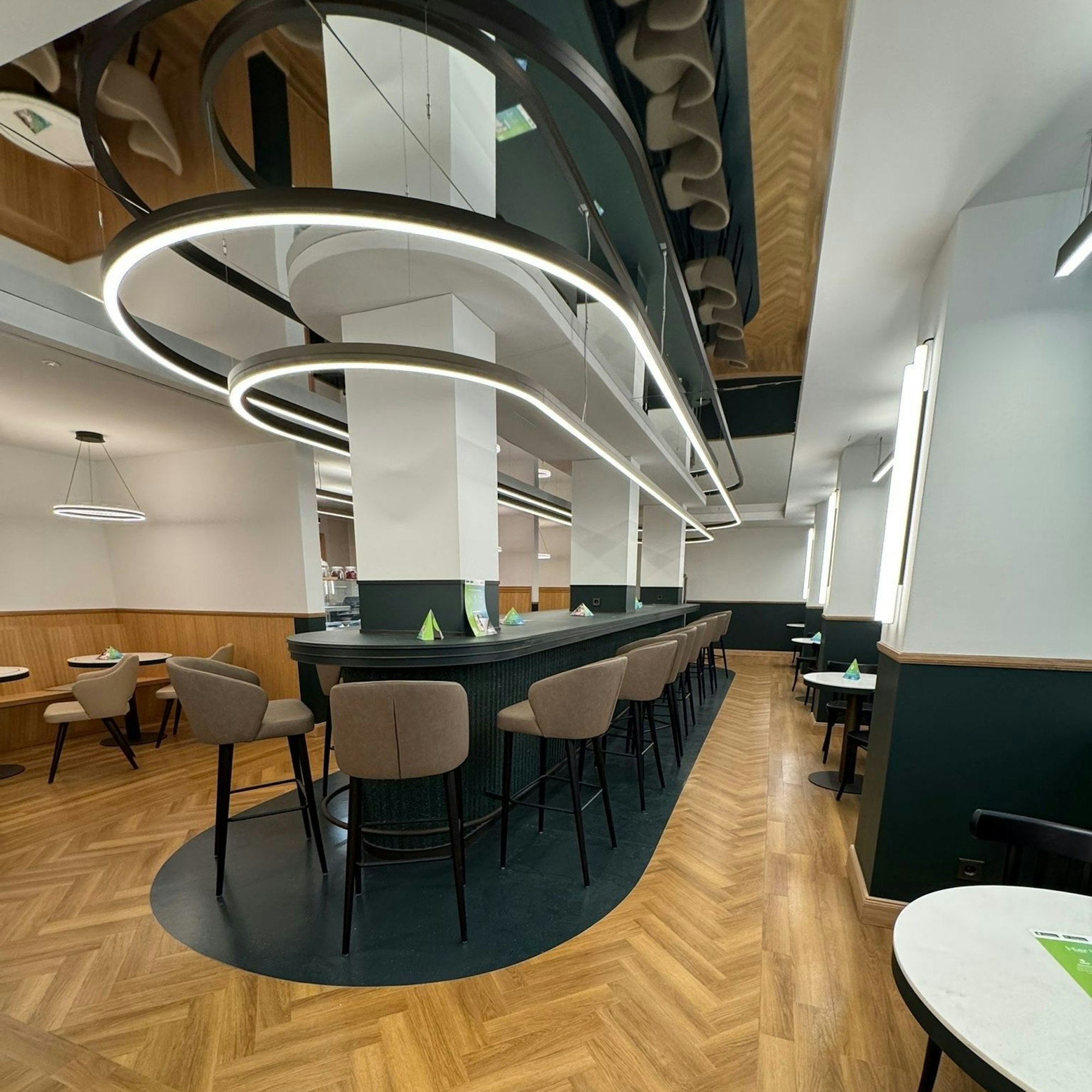 Das Bistro ist zu sehen ohne Gäste: ein schicker Thekenbereich mit gepolsterten Hochstühlen.