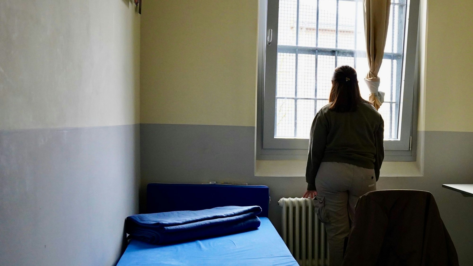 Die 21-Jährige Naomi steht am Fenster ihrer Zelle in der JVA Wuppertal.