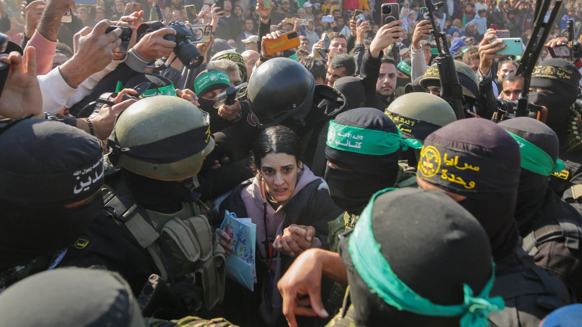 Die Deutsch-Israelin Arbel Yehud, die seit dem 7. Oktober 2023 von der Hamas im Gazastreifen als Geisel festgehalten wurde, wird von Kämpfern der Hamas und des Islamischen Dschihad eskortiert, als sie dem Roten Kreuz übergeben wird.