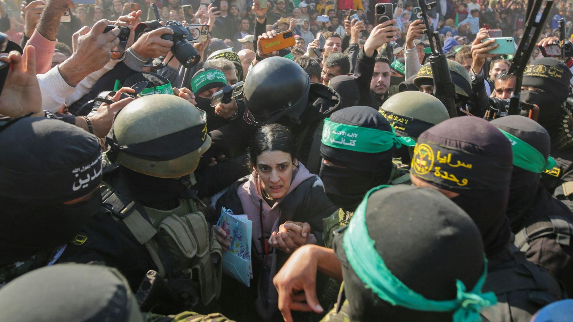 Die Deutsch-Israelin Arbel Yehud, die seit dem 7. Oktober 2023 von der Hamas im Gazastreifen als Geisel festgehalten wurde, wird von Kämpfern der Hamas und des Islamischen Dschihad eskortiert, als sie dem Roten Kreuz übergeben wird.