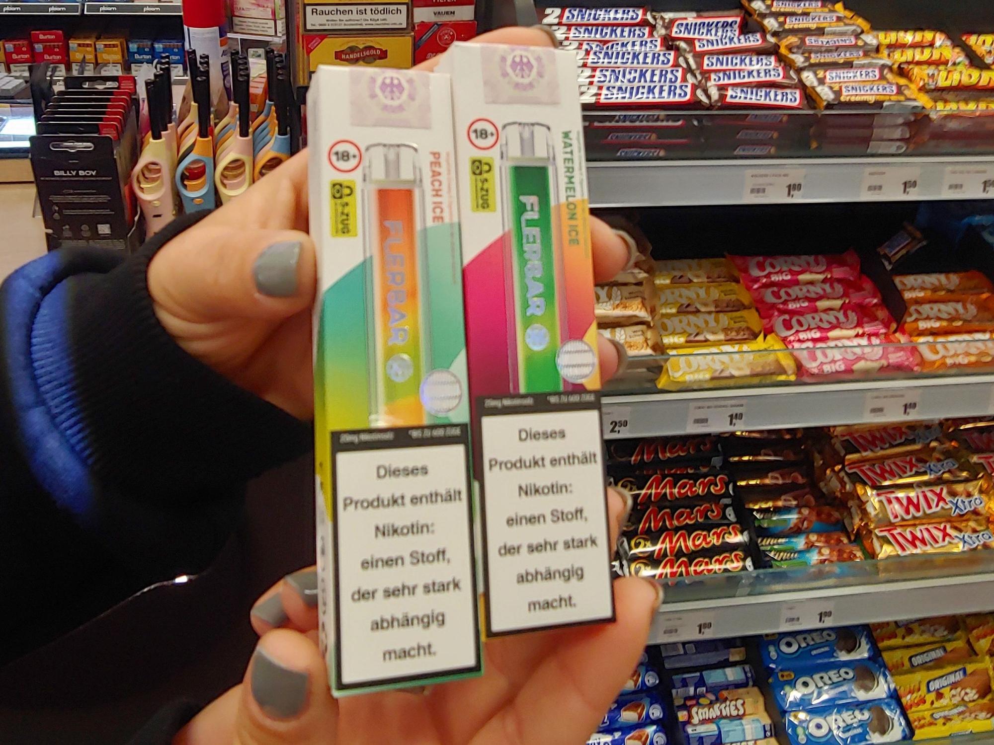 Zwei bunte Packungen mit E-Zigaretten, darauf ist ein Warnhinweis mit der Aufschriftt: „Dieses Produkt enthält Nikotin, einen Stoff, der sehr stark abhängig macht“