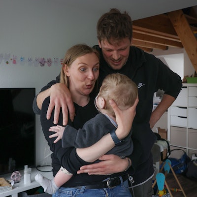 Mutter Leuschen hat ihre Tochter im Arm, der Vater hat den Arm um ihre Schulter gelegt.