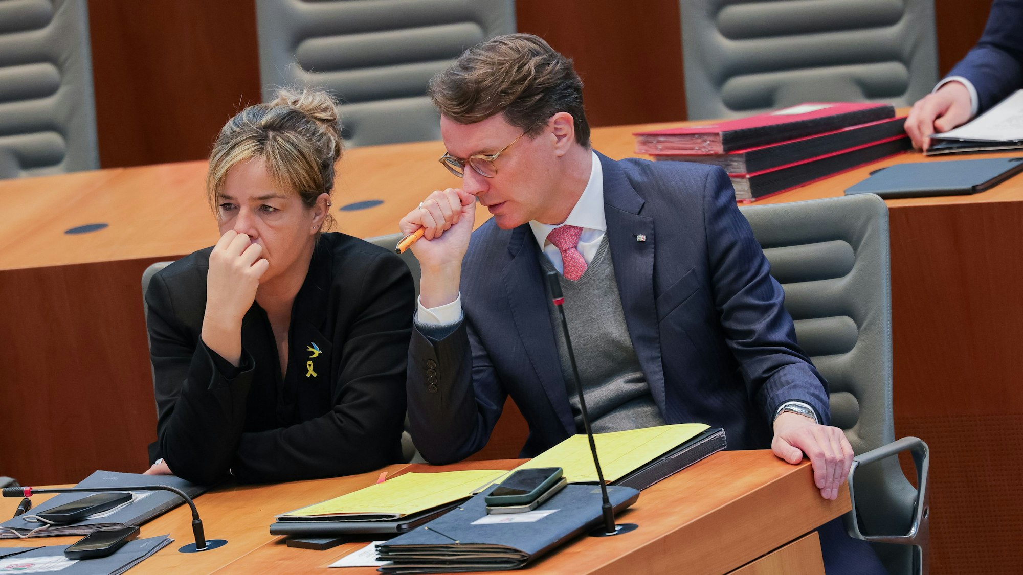 Schlechte Stimmung nachdem CDU-Chef Friedrich Merz einen Antrag im Bundestag mit Stimmen der AfD durchgebracht hat: NRW-Ministerpräsident Wüst (CDU) und seine Stellvertreterin Mona Neubaur (Grüne) bei der Plenarsitzung im Düsseldorfer Landtag.