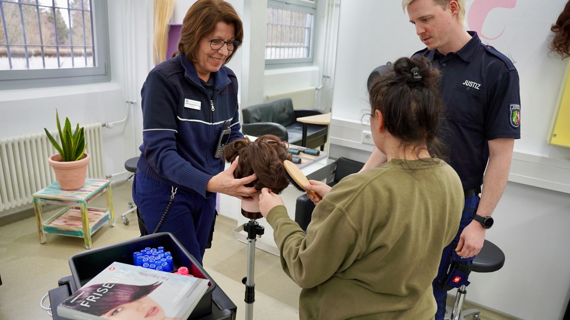 Eine weibliche Gefangene arbeitet im Friseursalon der JVA Wuppertal an einem Übungskopf.