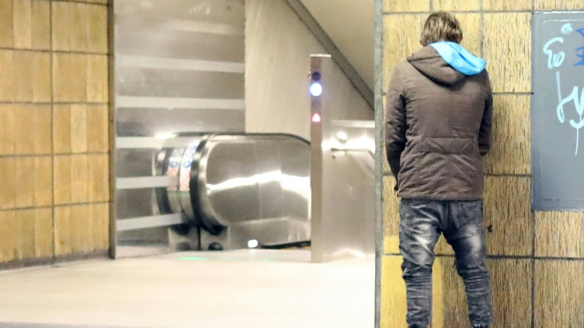 Ein Mann entleert sich an der U-Bahn Haltestelle Neumarkt.