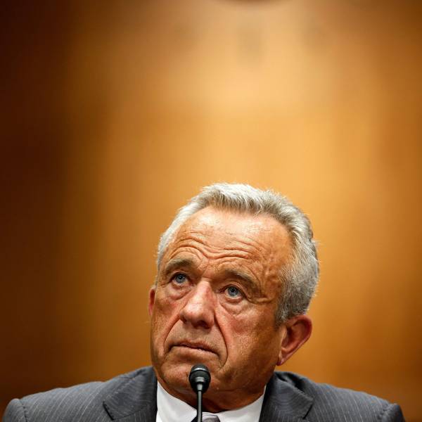 Portrait von Robert Kennedy, der hinter einem Mikrofon sitzt