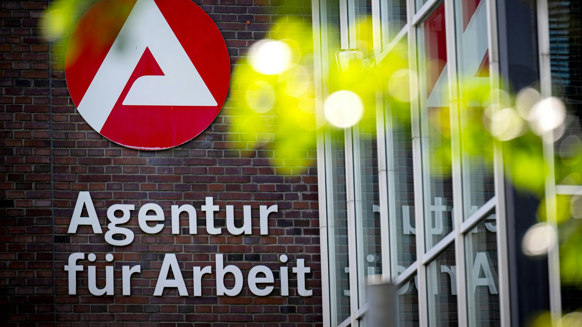 Der Schriftzug der Agentur für Arbeit hängt an einem Gebäude.