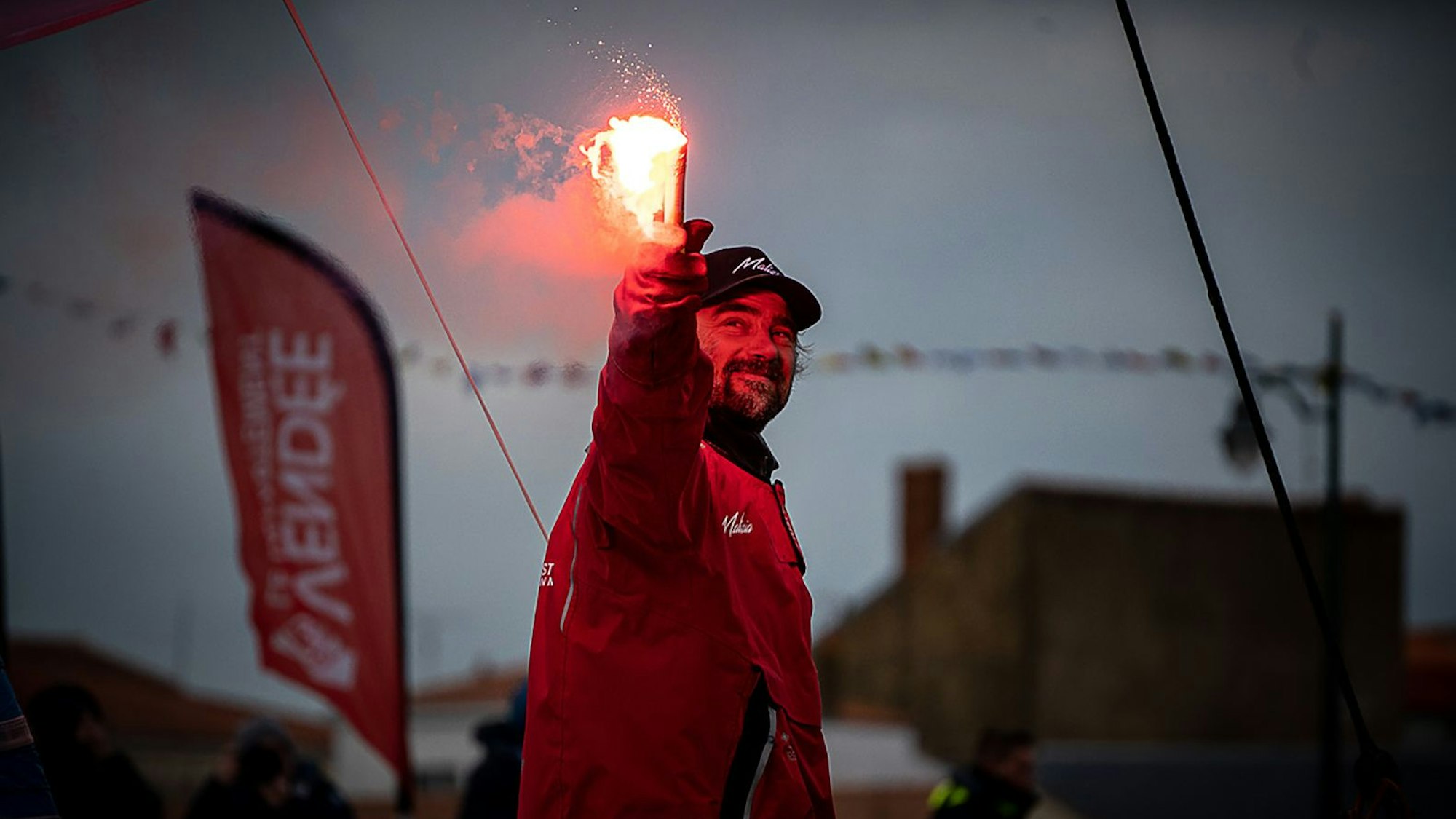Boris Herrmann zündet bei seiner Zielankunft in Les Sables d'Olonne eine Leuchtfackel.