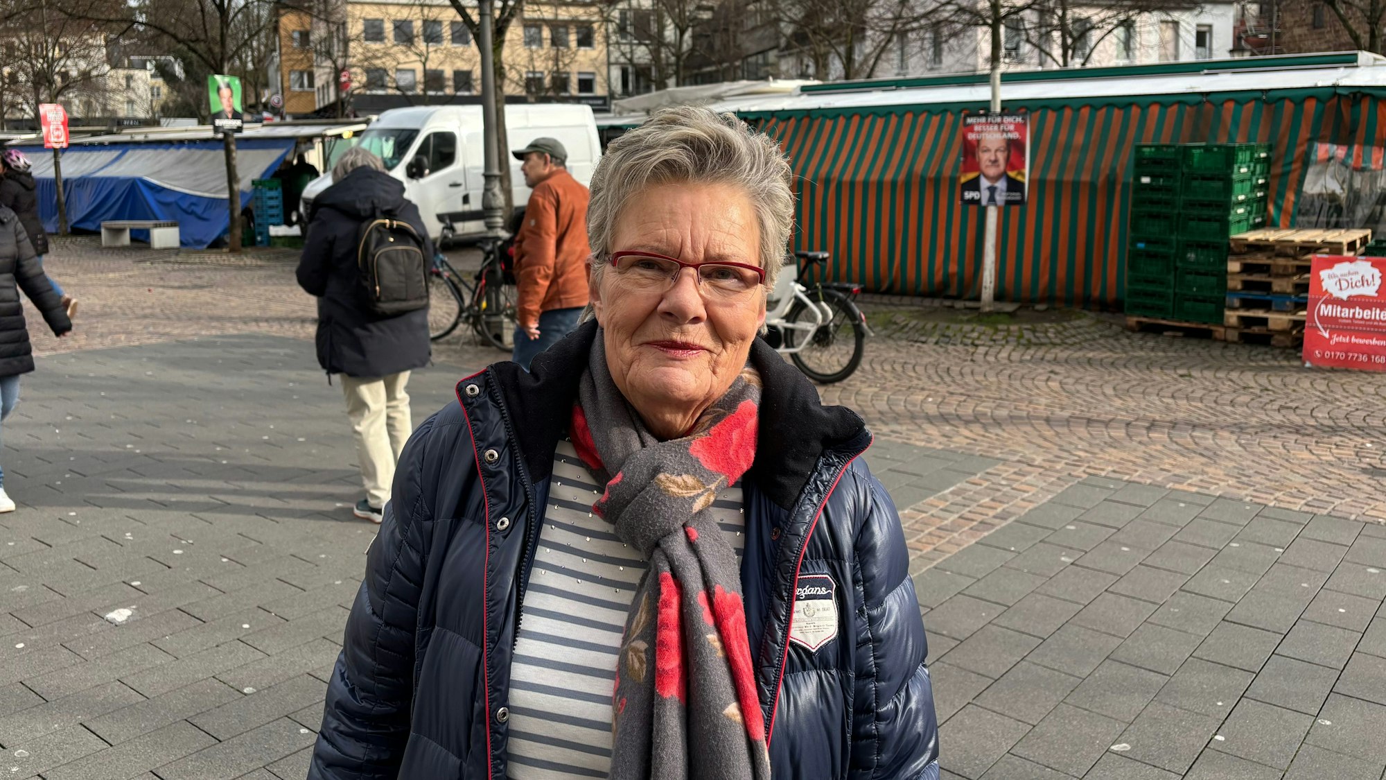 Eine ältere Frau steht in der Siegburger Fußgängerzone.