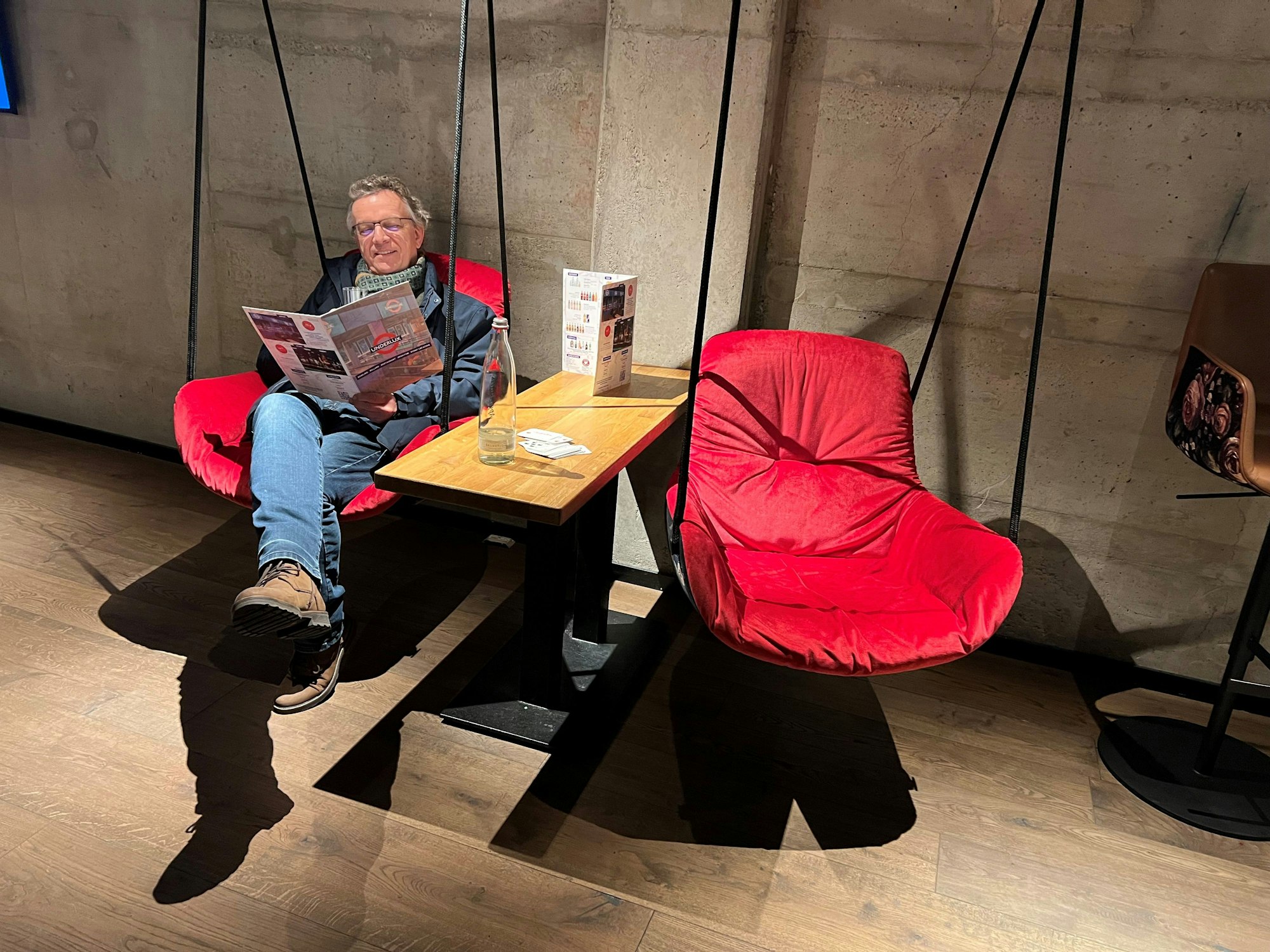 Hochwertige Möbel wie diese von der Decke hängenden, schwingenden Sitzschalen, geben dieser Sportbar ein besonderes Erscheinungsbild.