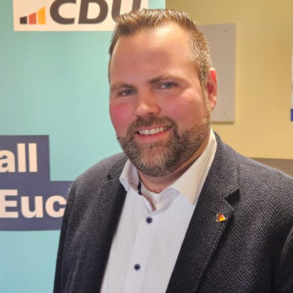 Michael Kehren steht vor einem CDU-Roll-up. Er trägt einen sauber gestutzten Bart, Sakko und ein weißes Hemd.