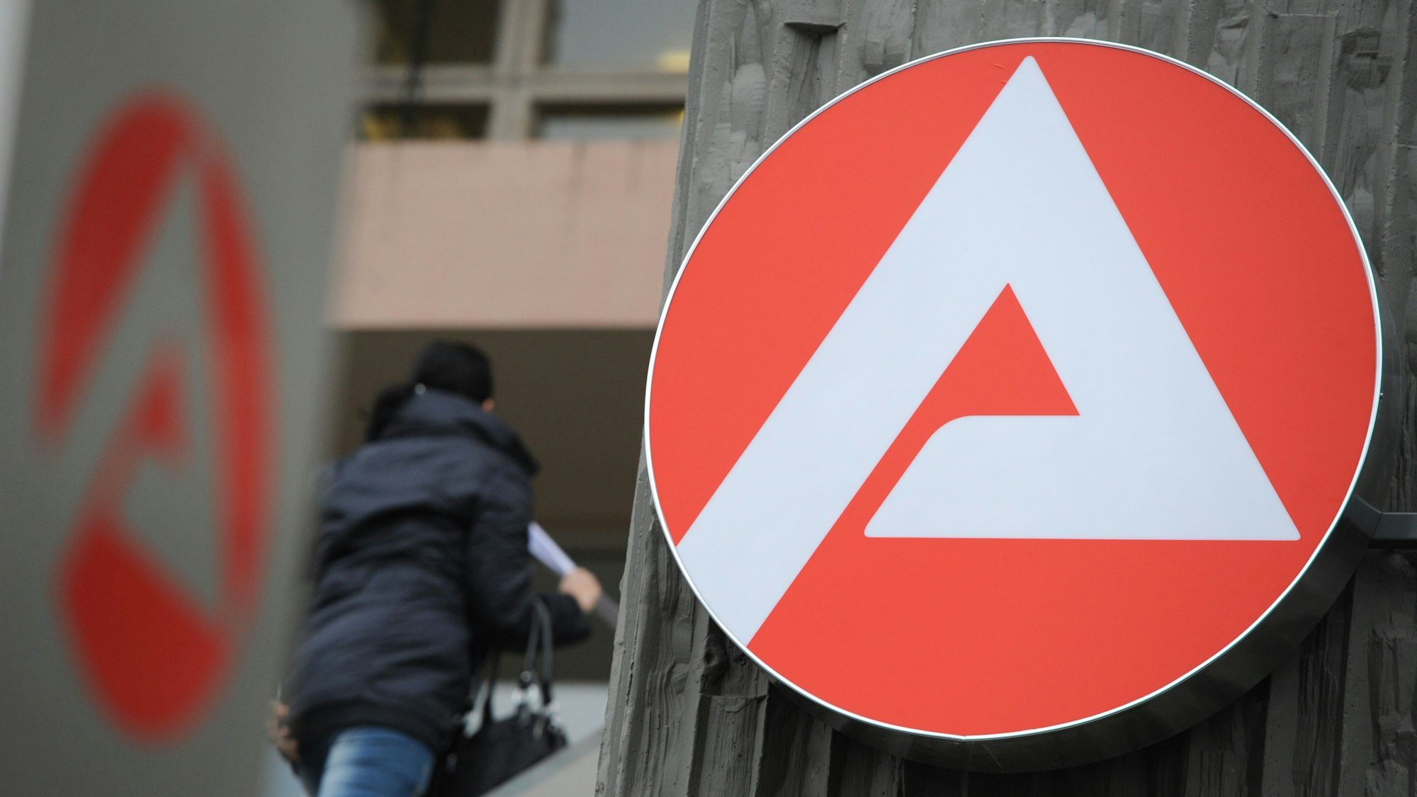 Eine Frau ist in Wiesbaden (Hessen) auf dem Weg zur Agentur für Arbeit.