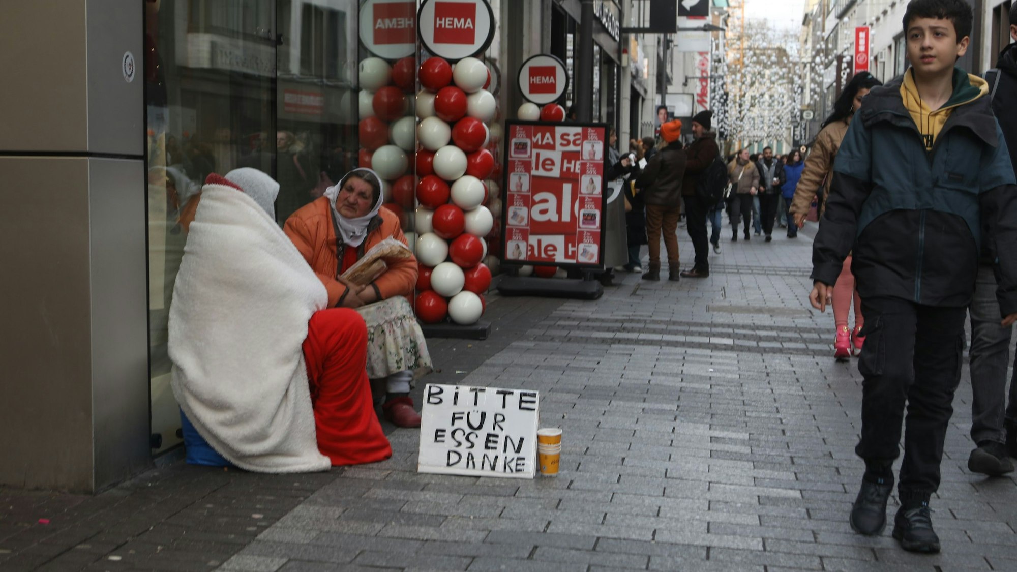 31.01.2025, Köln: Betteln mit System: Fast fast immer gleicher Wortlaut und Schrift auf den Kartons. Foto: Arton Krasniqi
