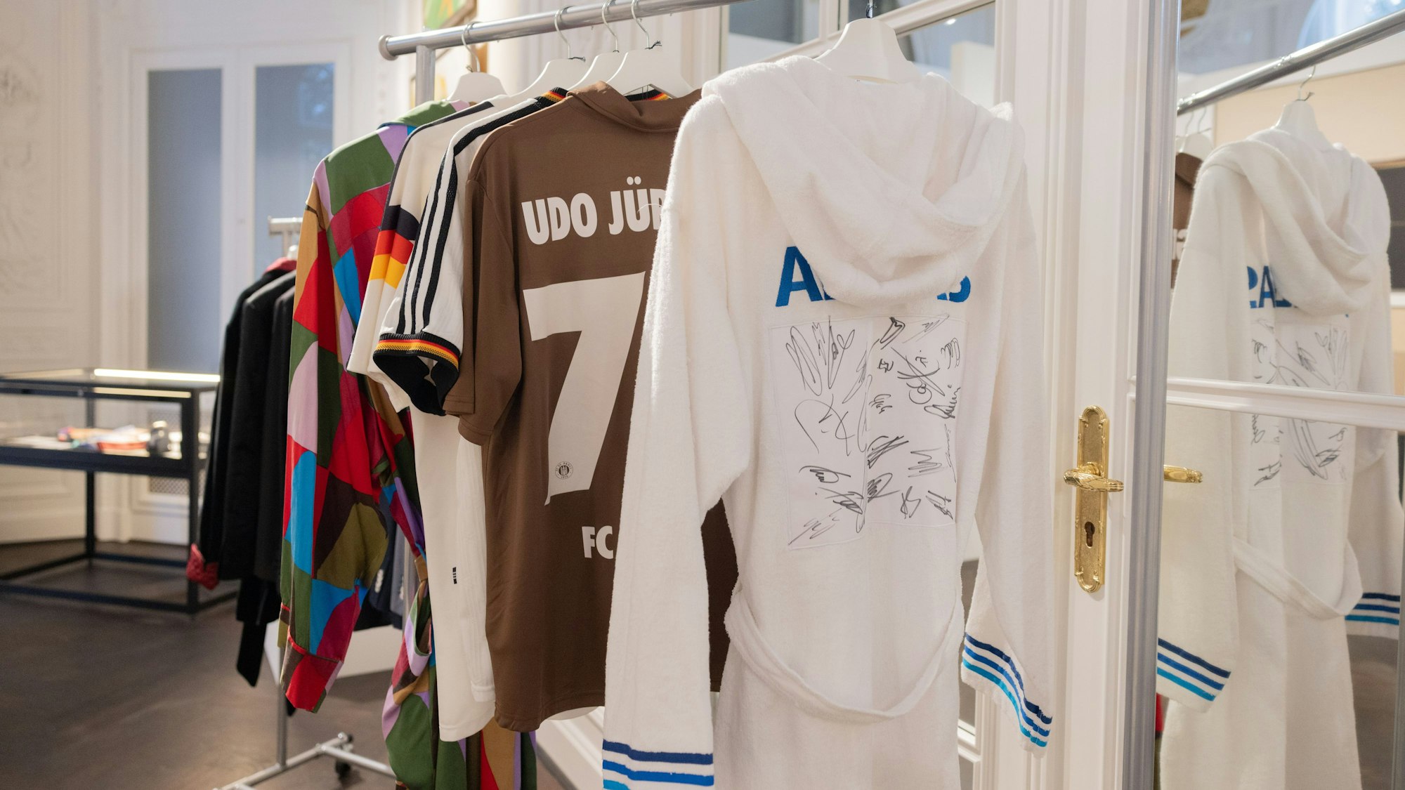 Ein von deutschen Fußballern signierter Frotteebademantel des Entertainers Udo Jürgens hängt im Auktionshaus Sotheby's.