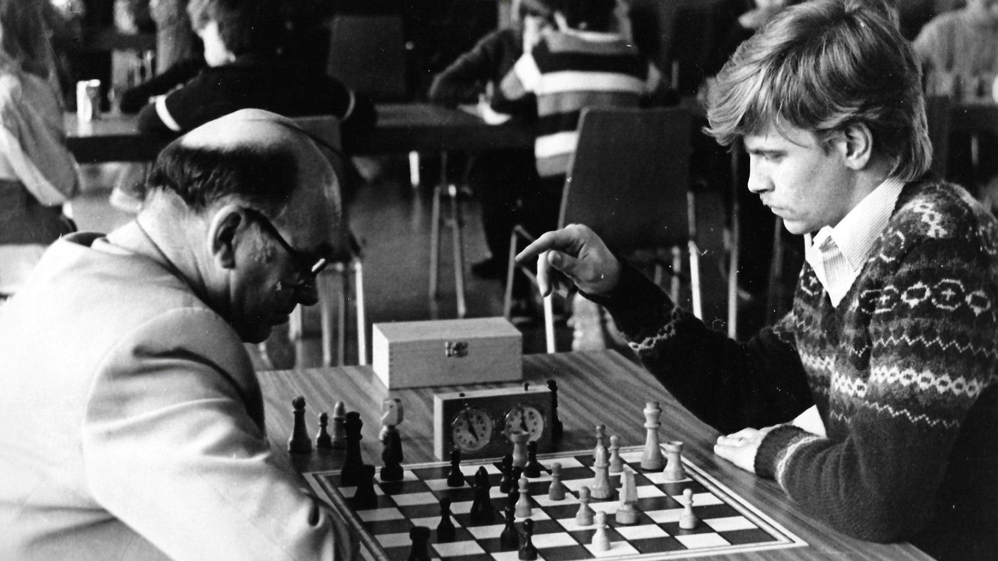 Auf dem schwarz-weiß-Foto sind zwei Männer zu sehen, die miteinander Schach spielen.