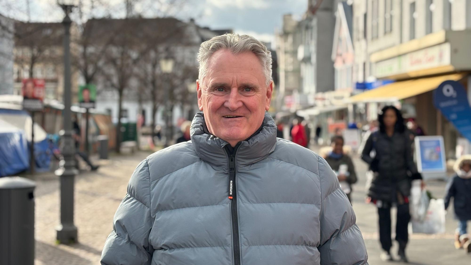Ein älterer Mann neben dem Siegburger Marktplatz.
