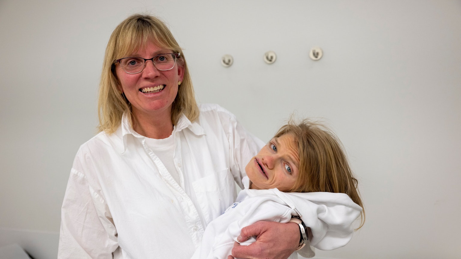 Ute Schneider hält ihre schwerbehinderte Tochter Laura im Arm und lacht in die Kamera.