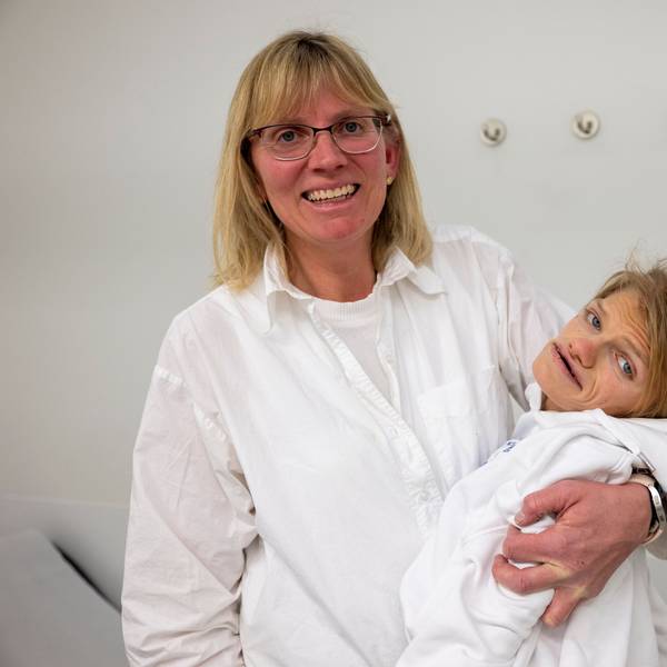 Ute Schneider hält ihre schwerbehinderte Tochter Laura im Arm und lacht in die Kamera.