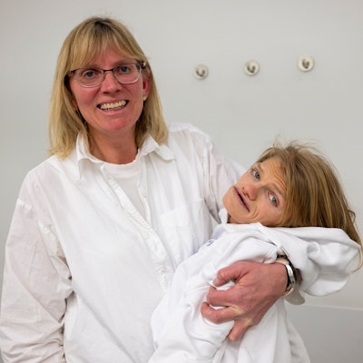 Ute Schneider hält ihre schwerbehinderte Tochter Laura im Arm und lacht in die Kamera.